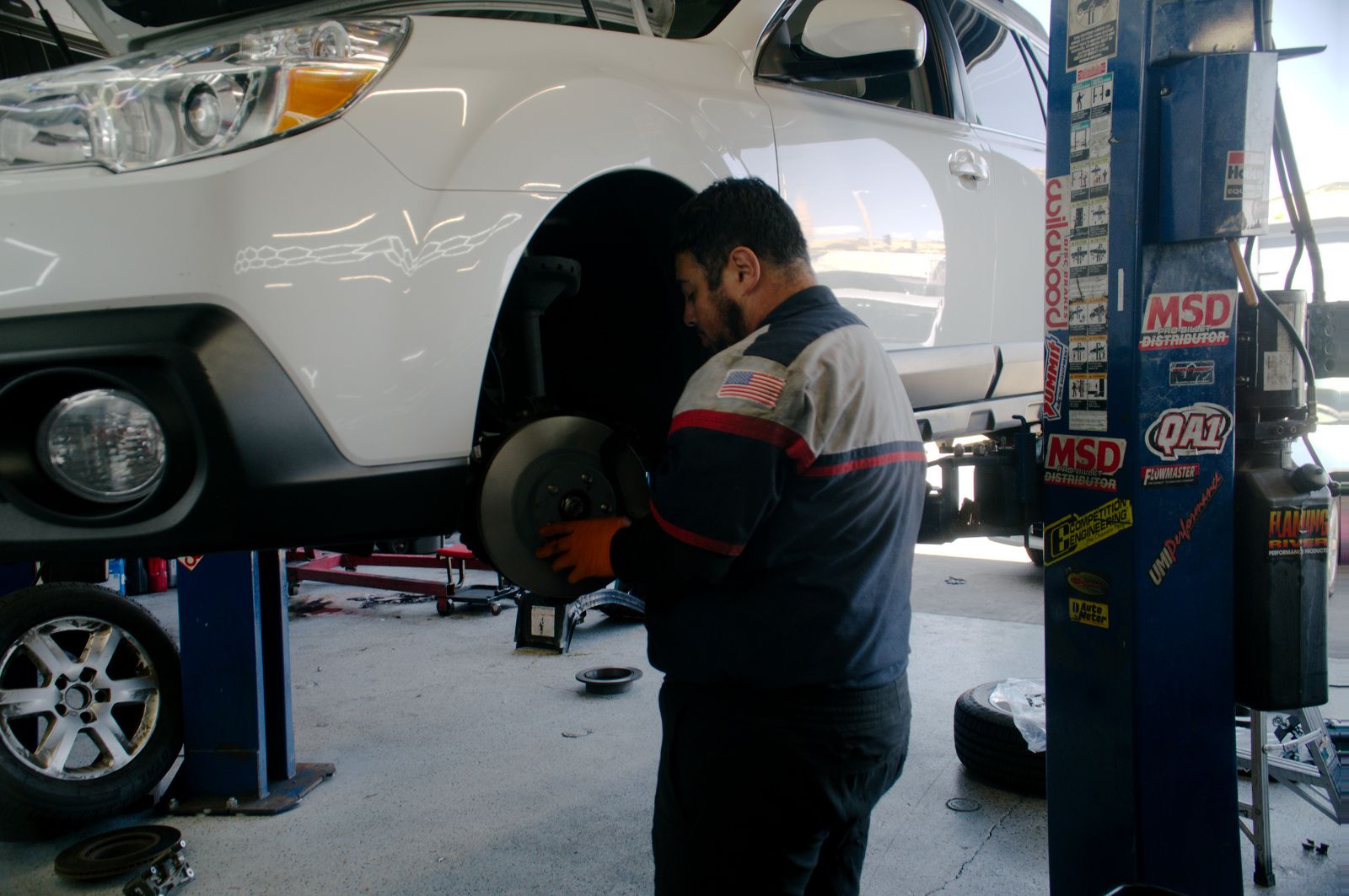 Bay Motors technician servicing the wheels and brakes on a lifted vehicle