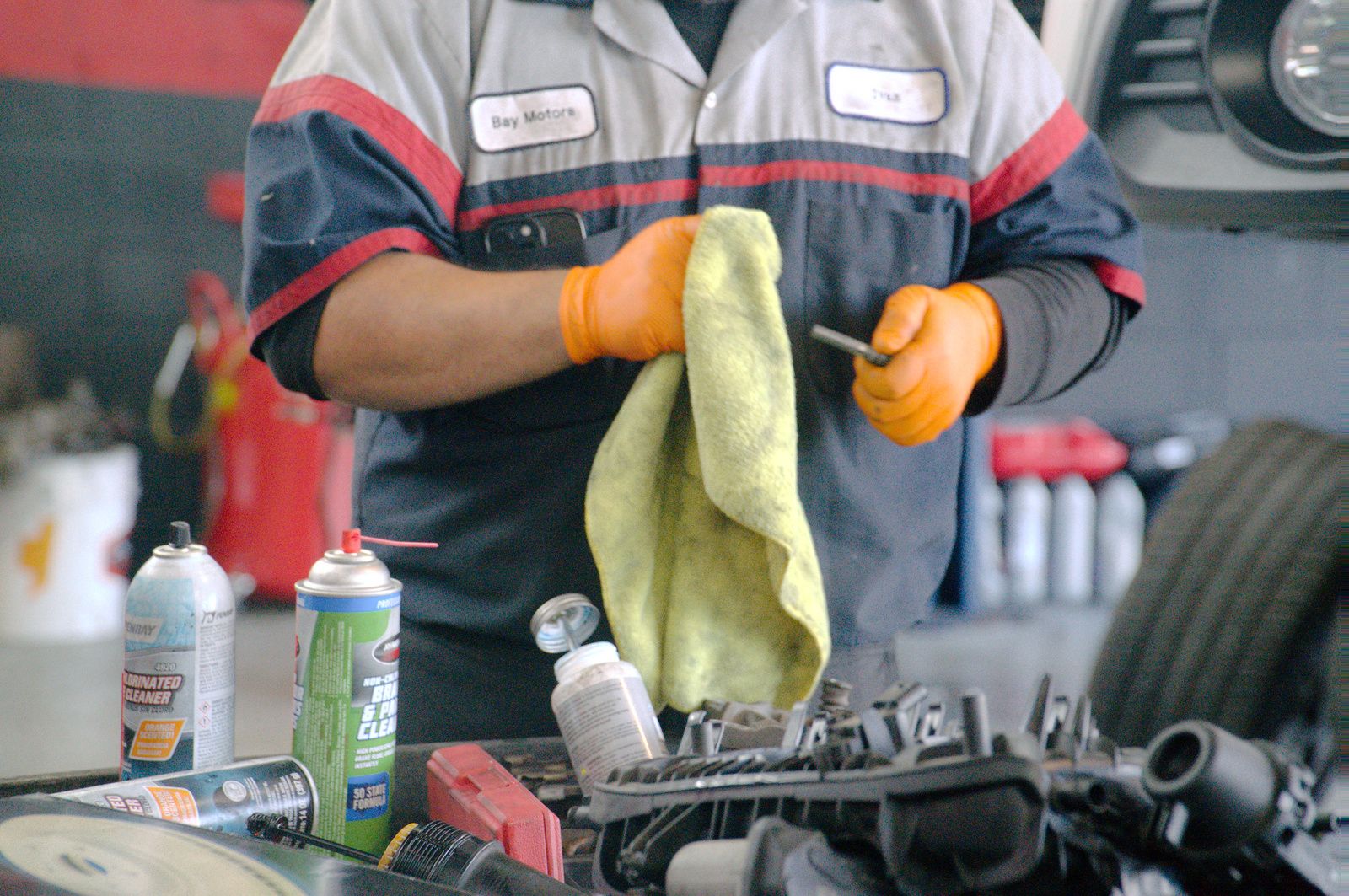 Bay Motors technician in uniform holding a part during service