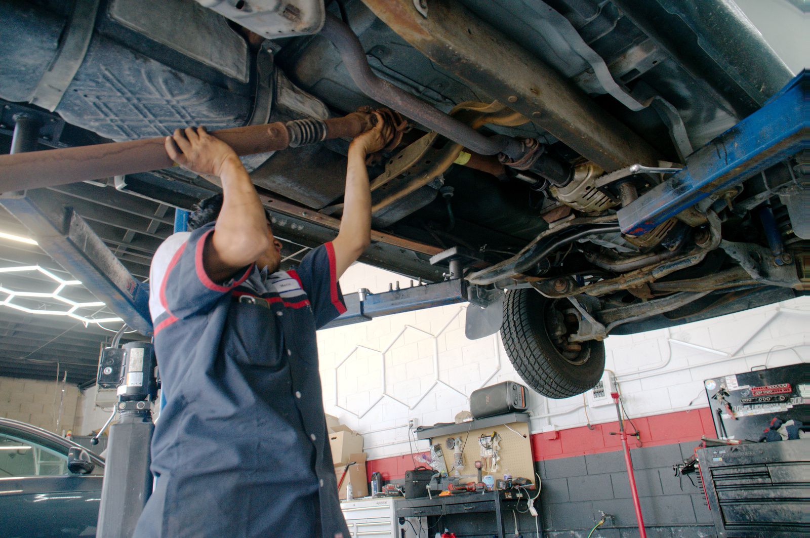 Bay Motors technician inspecting the underside of a vehicle on the lift
